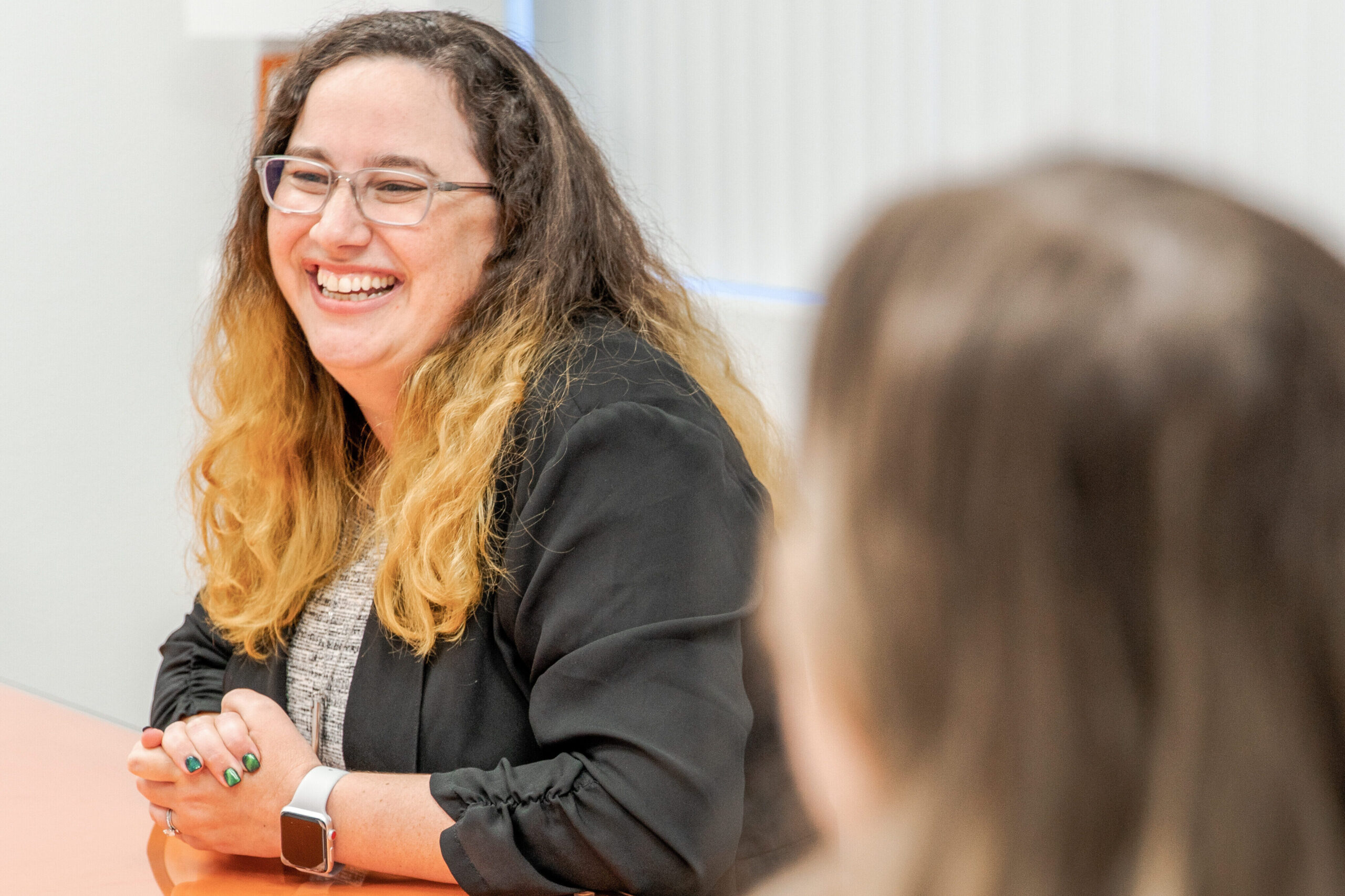 Jennifer smiling during a conversation at the office.
